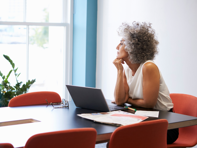 Woman staring out the window while sitting at a table